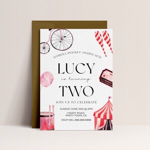 May include: A pink and white circus-themed birthday invitation for a girl turning two. The invitation features a pink and white bicycle, a pink cotton candy, a red and white striped tent, and a red and white striped juggling pin. The text on the invitation reads "Lucy is turning two. Join us to celebrate Sunday June 2nd at 2pm. 1 Party Road, Party Town, CA. RSVP Mel 888.888.8888."