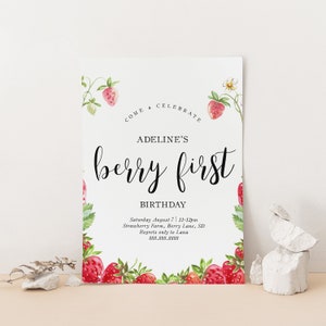 May include: A white card with a strawberry border and the text "COME & CELEBRATE ADELINE'S berry first BIRTHDAY Saturday August 7 11-12pm Strawberry Farm, Berry Lane, SD Regrets only to Lana 888.888.8888"