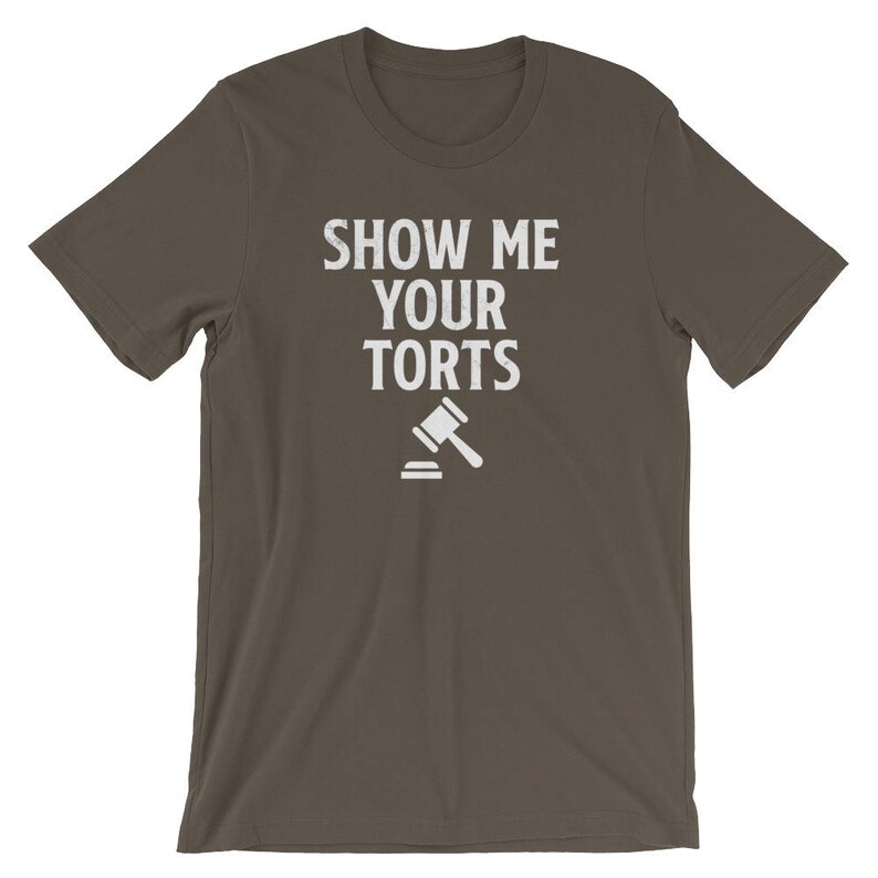 May include: A dark brown t-shirt with the text "Show Me Your Torts" in white lettering. A white gavel icon is below the text.