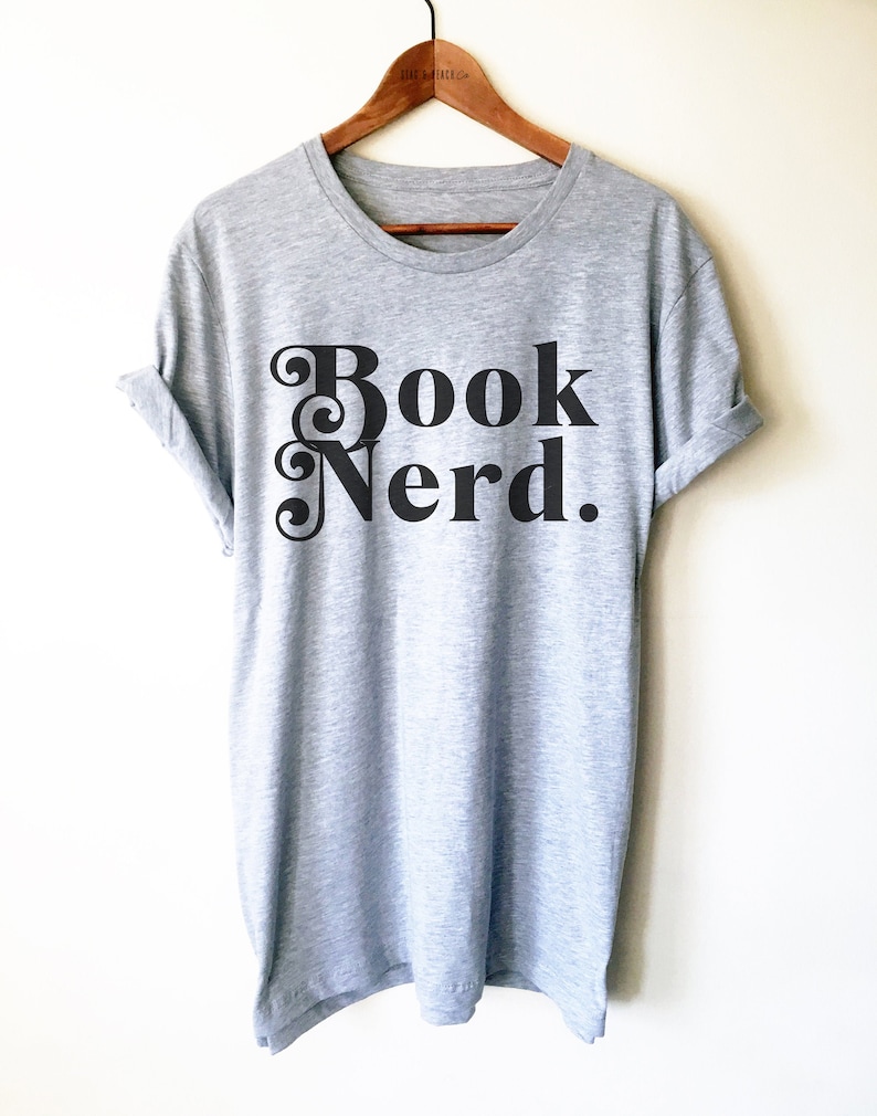 May include: A gray t-shirt with the text "Book Nerd." printed in black with a decorative font.