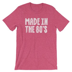 May include: A pink heather t-shirt with the text "MADE IN THE 80'S" in white.