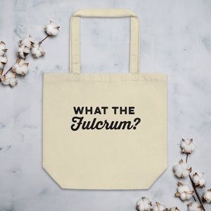 May include: A beige tote bag with black handles and the text "WHAT THE FULCRUM?" printed in black.