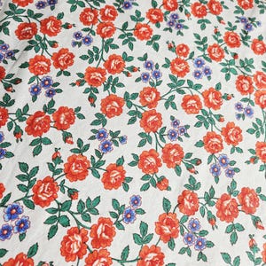 Weißer Baumwollstoff mit roten Rosen / blauen Blümchen