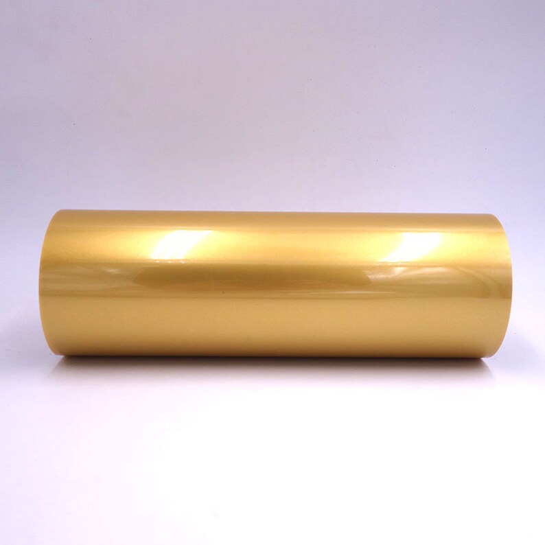 May include: A roll of gold vinyl adhesive film. The film has a shiny, metallic finish.