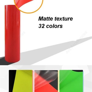 May include: A roll of red matte vinyl with a textured surface. The vinyl is available in 32 colors. The image shows a close-up of the vinyl and a sample of the vinyl with the protective film peeled back.