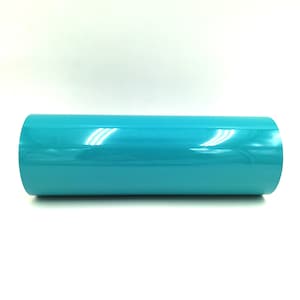 May include: A roll of turquoise vinyl adhesive film. The film is shiny and has a smooth surface.