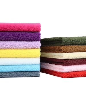May include: Two stacks of colourful, textured fabric. The left stack features pink, purple, yellow, blue, and grey. The right stack has green, brown, cream, burgundy, pink, and red. The fabric has a soft, fluffy texture.
