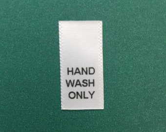 100 pcs of HAND WASH ONLY printed on white satin material.