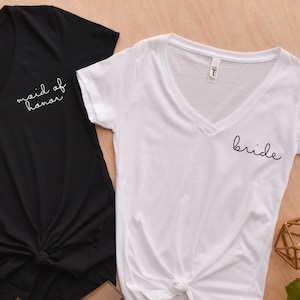 May include: Two V-neck t-shirts, one black and one white, with the text "maid of honor" and "bride" printed on them.