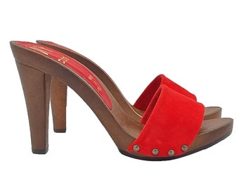 May include: Red suede heeled clogs with a wooden platform and a brown heel. The clogs have a silver stud detail on the front.