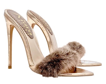 May include: Rose gold heeled sandals with a brown fur strap. The sandals have a pointed toe and a stiletto heel.