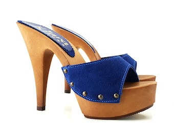 May include: Blue suede heeled clogs with a wooden platform and stiletto heel. The clogs have a decorative row of silver studs around the top edge of the platform.
