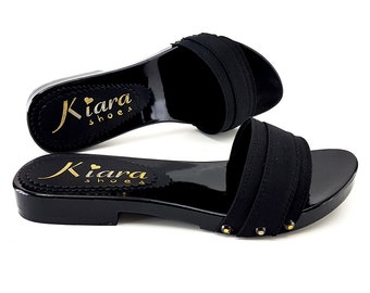 May include: Black leather slide sandals with a gold logo that says "Kiara shoes" on the insole. The sandals have a black fabric strap with a gold stud detail.