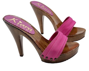 May include: A pair of pink wooden platform clogs with a high heel. The clogs have a pink fabric strap and are decorated with small silver studs.