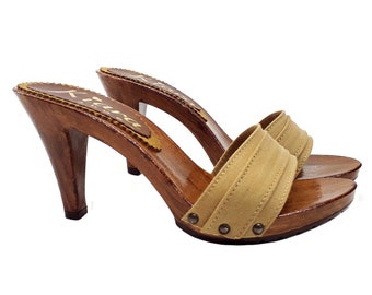 May include: Beige fabric heeled clogs with a wooden platform and heel. The clogs have a single strap across the top and are decorated with small metal studs.