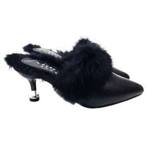 May include: Black slip-on heels with a pointed toe and a small, silver-toned heel. The top of the shoe is adorned with fluffy black feathers. The brand name "Alan Shoe" is visible on the insole.