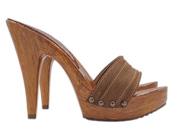 May include: Brown suede heeled clogs with a wooden platform and heel. The clogs have a single strap across the top of the foot and are decorated with small metal studs.