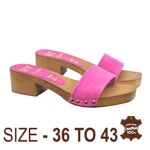 May include: Pink suede clogs with wooden soles and a gold logo that says "MY LOGS" and "MADE IN ITALY". The clogs are available in sizes 36 to 43.