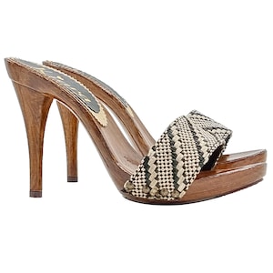 May include: Brown wooden platform clogs with a black and beige woven strap. The clogs have a high stiletto heel.
