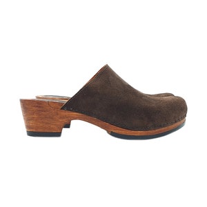 Könnte beinhalten: Braune Wildledersandalen mit einem Holzabsatz und einer braunen Sohle.