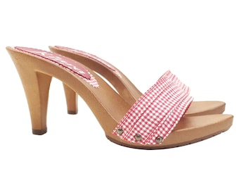 May include: Red and white gingham clog with a wooden heel and platform. The clog has a pointed toe and a buckle closure.