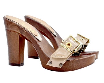 May include: A pair of brown wooden platform clogs with a beige buckle strap. The clogs have a high heel and a platform sole.