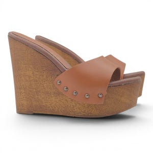May include: A tan leather slide sandal featuring a high wedge heel with a wood grain texture. The wide strap is secured to the platform base with four small silver-toned metal studs along the side, providing a sturdy construction for the footwear.