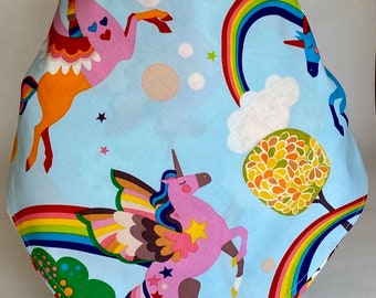 May include: A blue bandana with a whimsical design featuring pink unicorns, rainbows, and stars. The unicorns have wings and are flying through the sky.