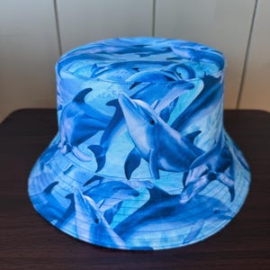 Dolphins swimming Bucket Hat Reversible, all cotton Bright sea blue with blue ocean waves and ripples as the reverse. Hawaii style hat XS-XL