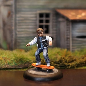 KIDS ON WHEELS 28mm rpg miniature - Patrick - boy on a skateboard. “Sold unpainted”.