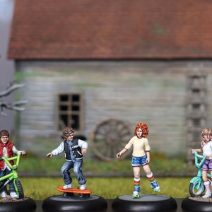 May include: Four painted figurines of children, each holding a different mode of transport. One child is riding a green and black bicycle, another is riding a blue and white bicycle, another is riding a skateboard, and the last child is on roller skates.