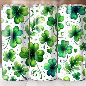 May include: Three stainless steel tumblers with a white background and a green four-leaf clover pattern.