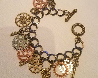 Charm Bracelet.  bronze chain and toggle clasp with bronze, copper and silver colored key and gear charms.  Steampunk!