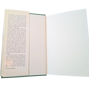 Puede incluir: Libro abierto con texto en la p&aacute;gina izquierda y una p&aacute;gina derecha en blanco. El texto describe la historia de la esclavitud en Brasil. El libro tiene una cubierta verde y un marcador blanco. El texto incluye la frase "First published in French in 1979."