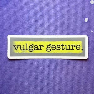 May include: A gray sticker with a yellow background and the text "vulgar gesture."