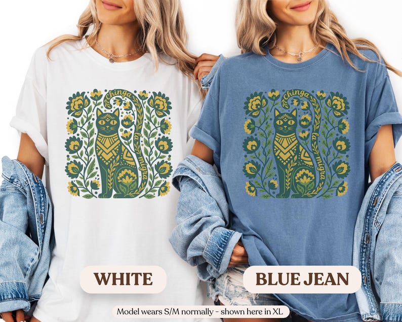 May include: White and blue jean t-shirts featuring a green cat design with floral accents. The cat has a decorative pattern and the text "chinga la migra". The shirts are a relaxed fit.