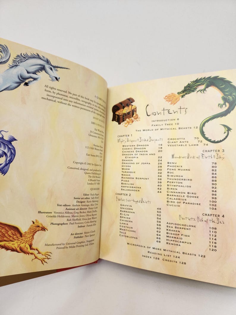 May include: A book open to the contents page, featuring illustrations of a unicorn, a griffin, and a green dragon. The text lists chapters on mythical beasts, including dragons, serpents, and birds, with page numbers for each entry in the book.