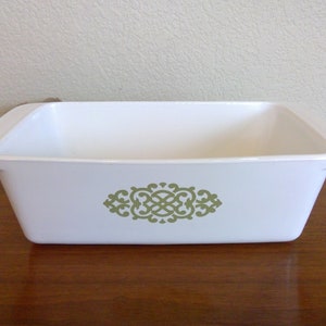 May include: White ceramic loaf pan with a green floral design.