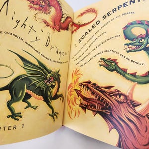 May include: An open book page featuring illustrations of dragons with text reading Mighty Dragons, Chapter 1, Scaled Serpents, The dragon is the oldest and largest of all beasts, It is king of the western earth and emperor of the far eastern sky.