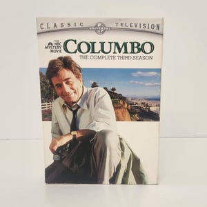 May include: A DVD box set for the television show "Columbo: The Complete Third Season." The box features a photo of the actor Peter Falk, with the show's title and branding prominently displayed. The box is white with a glossy finish.