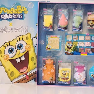 May include: A SpongeBob SquarePants x Wet n Wild makeup set. The box features SpongeBob and the Wet n Wild logo. The set includes various makeup items in clear plastic packaging, with SpongeBob and nautical-themed designs. The color palette includes yellow, pink, and blue.