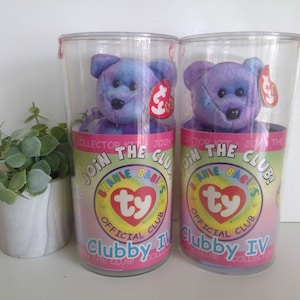 May include: Two purple and blue Beanie Babies Clubby IV plush toys in clear plastic containers with the Ty logo and "Join the Club!" text.