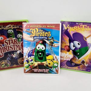 May include: Three VeggieTales DVDs. The center DVD is "The Pirates Who Don't Do Anything." The left DVD is "The Star of Christmas." The right DVD is "LarryBoy and the Bad Apple." All DVDs have green cases.