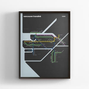 Peut inclure: Affiche encadrée représentant une carte stylisée du réseau de transport en commun Translink de Vancouver. La carte est réalisée dans un style minimaliste avec un fond gris foncé et des lignes colorées représentant les différents itinéraires. Le texte "vancouver translink" est en haut.