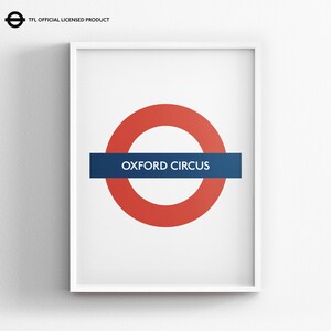 May include: A framed wall print featuring the iconic London Underground roundel logo with a red circle and a blue horizontal bar containing the white text OXFORD CIRCUS. The top left corner displays the text TFL OFFICIAL LICENSED PRODUCT.