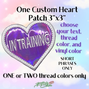 May include: A custom heart-shaped patch, 3" x 3", with the text "IN TRAINING" in silver thread. The patch has a holographic purple center and a silver embroidered border. The image includes text that says "choose your text, thread color, and vinyl color."