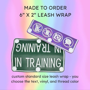 May include: Made-to-order leash wraps. One is green with white text reading "IN TRAINING". The other is iridescent purple with white symbols. Each wrap is 6" x 2".