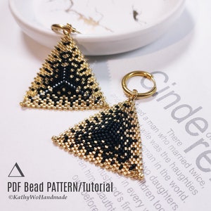 May include: A pair of triangle-shaped earrings made with black and gold beads. The earrings are hanging from gold hoops.