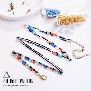 Op de afbeelding: Een kleurrijke kralenketting met een geometrisch patroon in tinten blauw, rood, wit, goud en zwart. De ketting ligt op een wit oppervlak met een gouden ketting en sluiting. De tekst "PDF Bead Pattern ©KathyWoHandmade" is zichtbaar in de linkerbenedenhoek van de afbeelding.