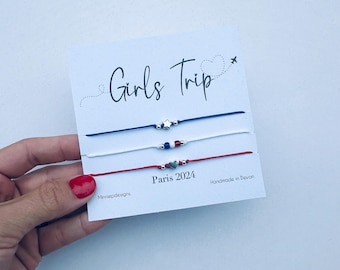 May include: Three friendship bracelets with star and heart charms. The bracelets are red, white, and blue. The card reads "Girls Trip Paris 2024" and "Handmade in Devon".